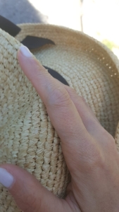 la mano di Rebecca su cappello di paglia